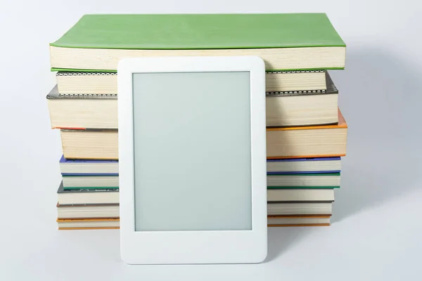 Ebook reader next to paper books