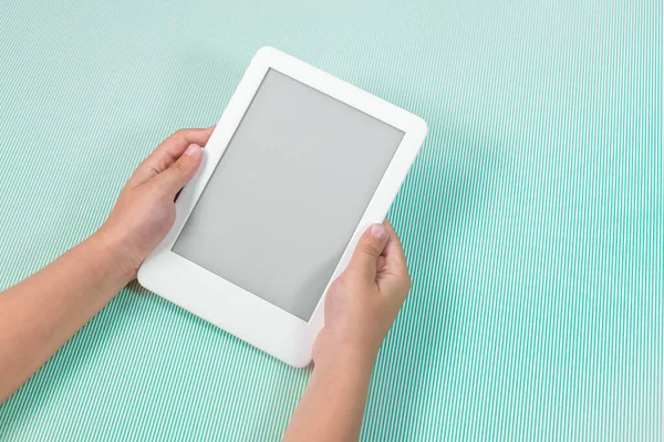 Ebook reader over green background - being held by the hand of a child