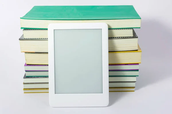 Ebook reader next to paper books