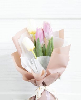 Beyaz ahşap çerçeve üzerinde lale buketi.