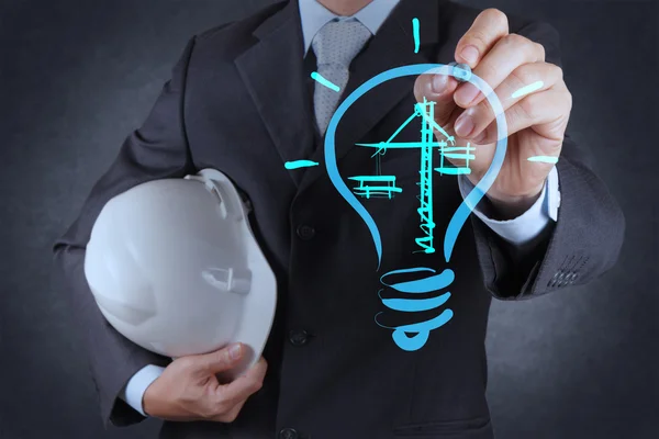 Engineer drawing lightbulb and construction — Stockfoto