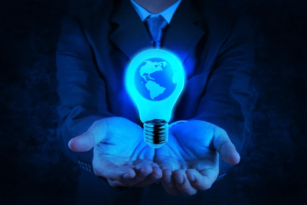 Empresário mão mostra lâmpada com planeta Terra — Fotografia de Stock