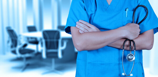 Doctor with a stethoscope in the hands and office background