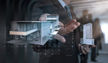 işadamı el ev modeli üzerinde modern bilgisayar sunar.