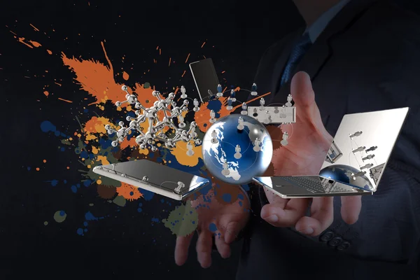Бизнесмен демонстрирует современные технологии и брызги цветов — стоковое фото