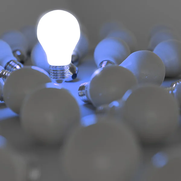 Growing light bulb standing out from the unlit incandescent bulb — Stock Photo, Image