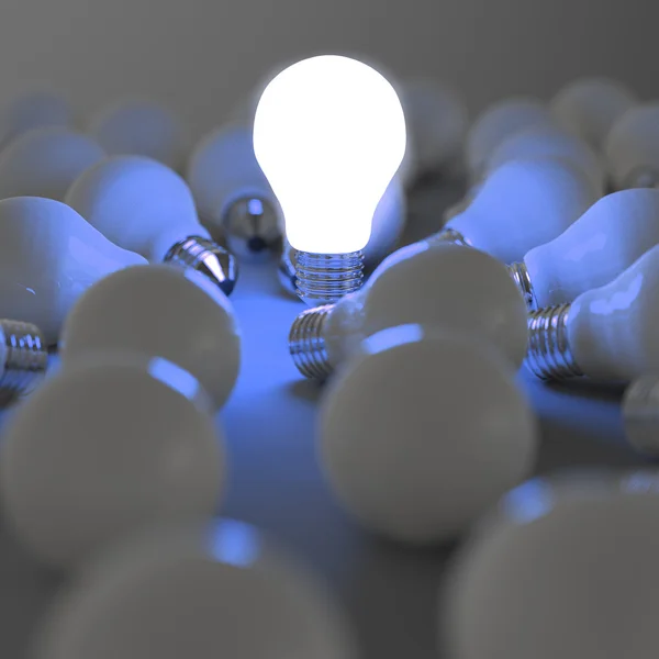 Growing light bulb standing out from the unlit incandescent bulb — Stock Photo, Image