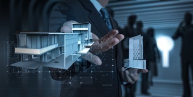 işadamı el ev modeli üzerinde modern bilgisayar sunar.