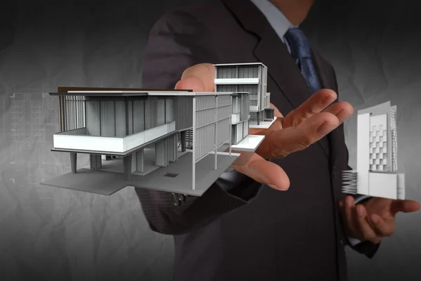 Empresario mano muestra modelo de casa con fondo de papel arrugado —  Fotos de Stock
