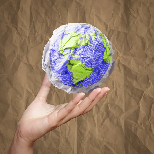 Hand showing crumpled world paper symbol — Stock Photo, Image