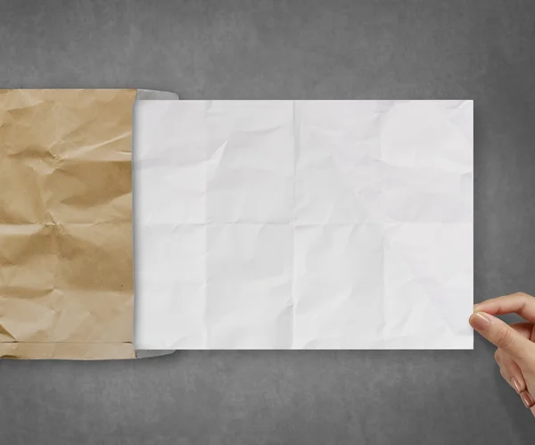 Hand trekken verfrommeld papier uit recycle envelop — Stockfoto