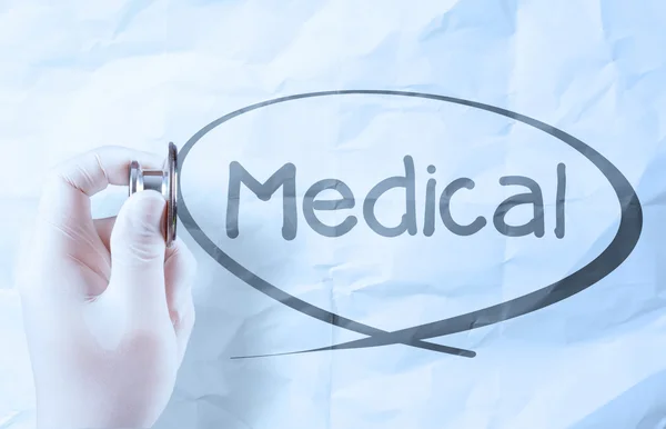 Ruka drží stetoskop ukazuje lékařský koncept na zmačkaný papír — Stock fotografie