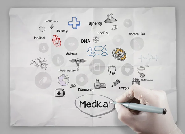 Läkare hand drar medicinsk ikoner på skrynkligt papper — Stockfoto