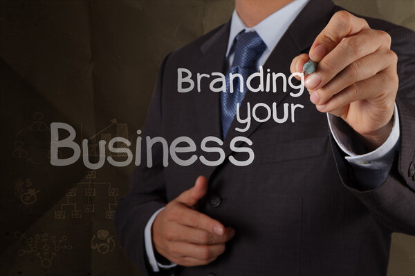 businessman hand writing branding your business with crumpled re