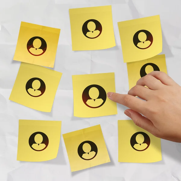 Hand pushing sticky note social network icon on crumpled paper — Stock Photo, Image