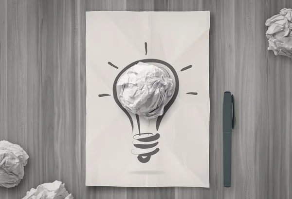 Gloeilamp op verfrommeld papier als creatief concept — Stockfoto