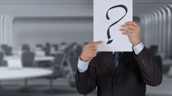 Businessman with question book on meeting room background — Stock Photo, Image