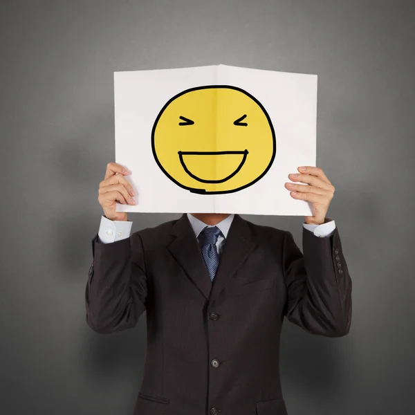 Geschäftsmann mit dem gemalten glücklichen Lächeln auf weißem Buch über seinem — Stockfoto