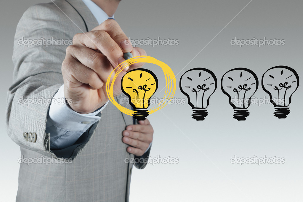 businessman hand drawing light bulb as creative concept