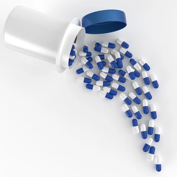 Таблетки, разлитые из бутылки с таблетками на белом — стоковое фото