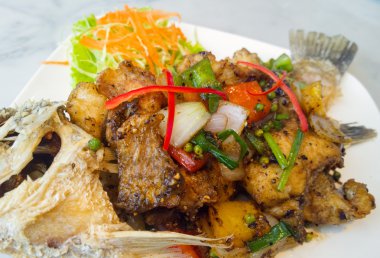 Baharatlı beyaz tabakta karabiber ile kızarmış levrek