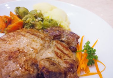 ızgara domuz biftek pişmiş patates ve sebze salatası