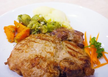 ızgara domuz biftek pişmiş patates ve sebze salatası