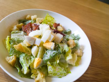  Sezar salatası ahşap bir masa üzerine yerleştirilen
