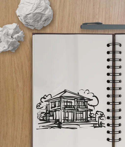 Hand drawing house on wrinkled paper with wooden table as concep — Stock Photo, Image