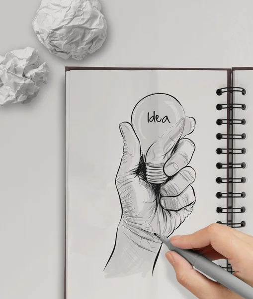 Hand getekend gloeilamp met idee woord op Opmerking boek als concept — Stockfoto