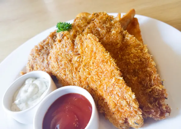 Fried chickens with dips on wooden table — Stock Photo, Image