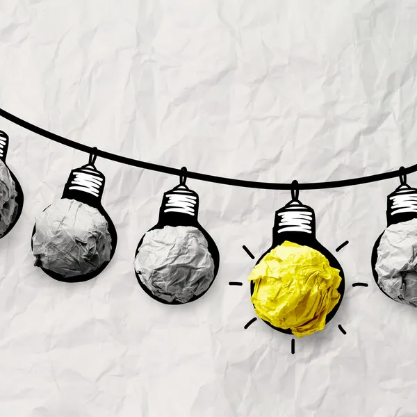 Hand drawn light bulb on wire doodle with crumpled paper as lead — Stock Photo, Image