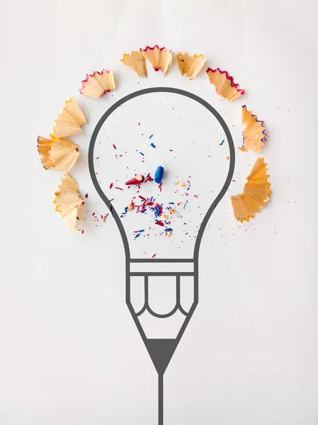 Graphic pencil  light bulb with pencil saw dust on paper backgro — Stock Photo, Image