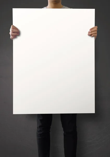 Hipster holding blank poster on texture wall as concept — Stock Photo, Image