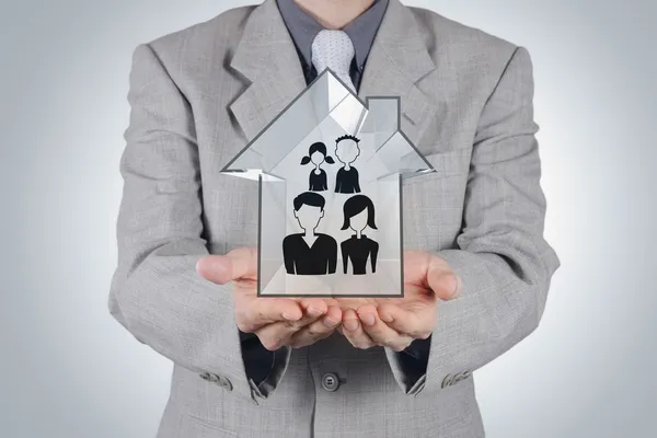 Uomo d'affari tenendo mano disegnato icona di famiglia e 3d casa come assicuratore — Foto Stock