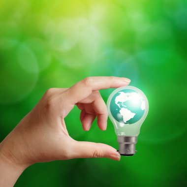 bir ampul enerji kavram olarak Dünya gezegeni tutan el