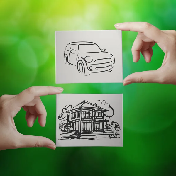 Hand holding hand drawn house and car on canvas board on nature — Stock Photo, Image
