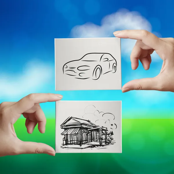 Hand holding hand drawn house and car on canvas board on nature — Stock Photo, Image
