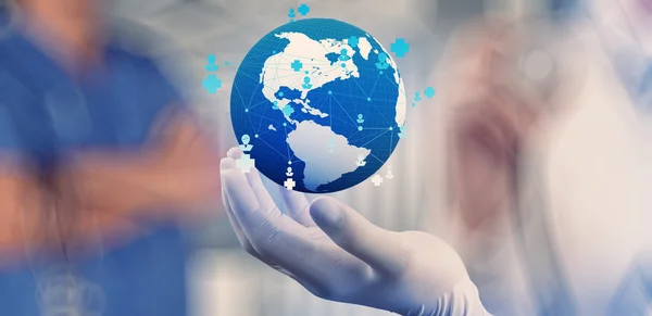Médico segurando um globo mundial em suas mãos como rede médica — Fotografia de Stock