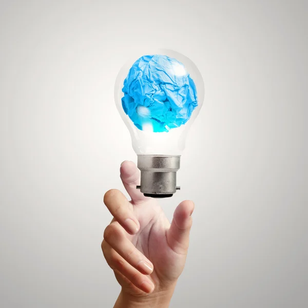 Hand showing light bulb crumpled paper as creative concept — Stock Photo, Image