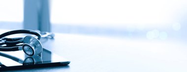 Studio makrosu bir stetoskop ve dijital tablet sığ Dof ile eşit olarak soyut ahşap masa arka plan kopya alanı üzerinde bahisler