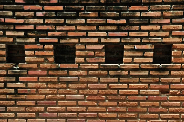 Parede de tijolo vermelho com porões quadrados para fundo — Fotografia de Stock