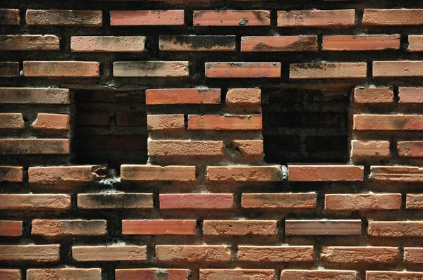 Rode bakstenen muur met twee vierkante houden — Stockfoto
