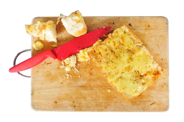 Garlic bread with red knife on the chopping block — Stock Photo, Image