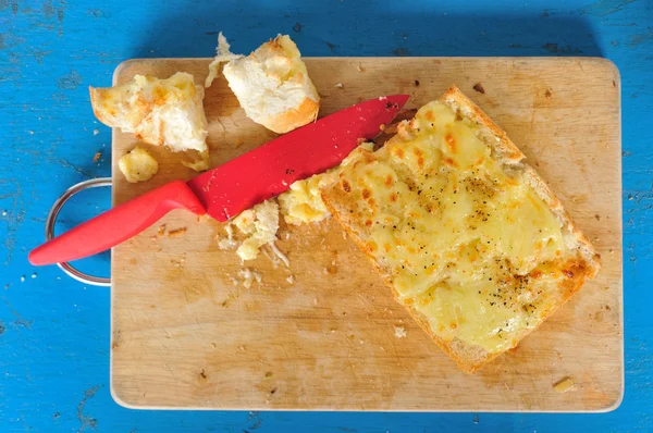 Вид зверху часниковий хліб з червоним ножем — стокове фото