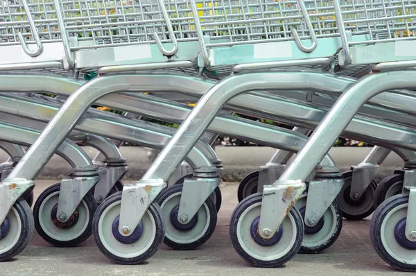 Rij van lege shopping carts in grote supermarkt — Stockfoto