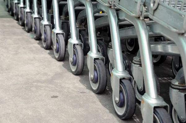 Row of empty shopping carts in big supermarket — Stock Photo, Image