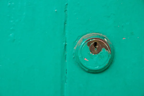 Vintage key hold on green door — Stock Photo, Image