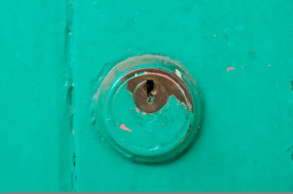 Vintage key hold on green door — Stock Photo, Image