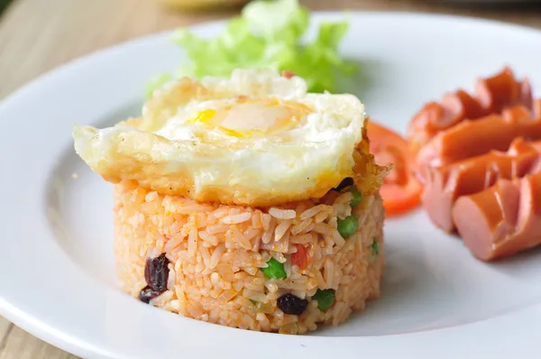 Жареный рис с яйцом и сосисками, смешивание с горохом, стручковой фасолью — стоковое фото
